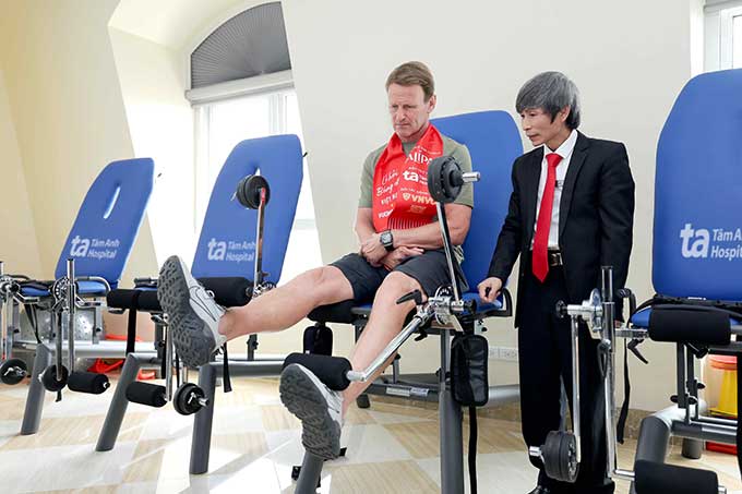  MSc Tran Van Dan, Head of Rehabilitation Department, Tam Anh General Hospital in Hanoi guided Teddy Sheringham to practice on the system of training equipment and strengthen the thigh quad -head muscle. Photo: Tam Anh General Hospital